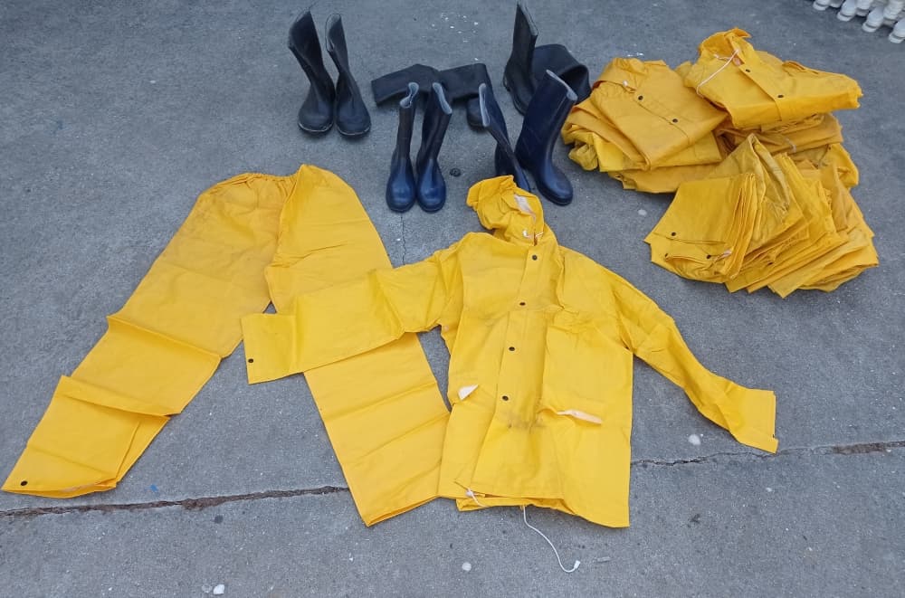 Capacetes, botas de segurança e fatos impermeáveis e fortes